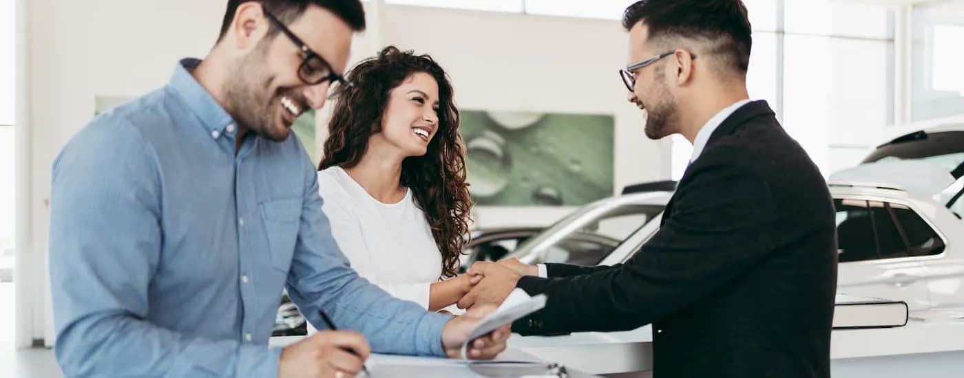 A salesman is shown speaking to customers at a Poughkeepsie Ford dealer.