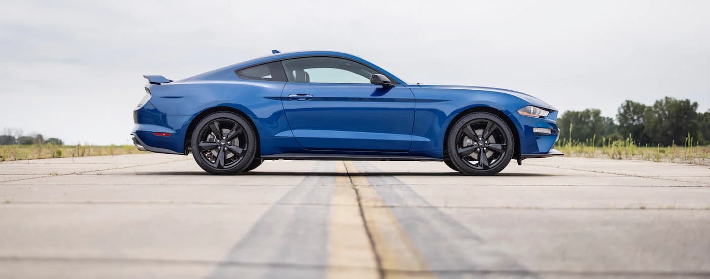 A blue 2022 Ford Mustang Ecoboost is shown from the side while parked.