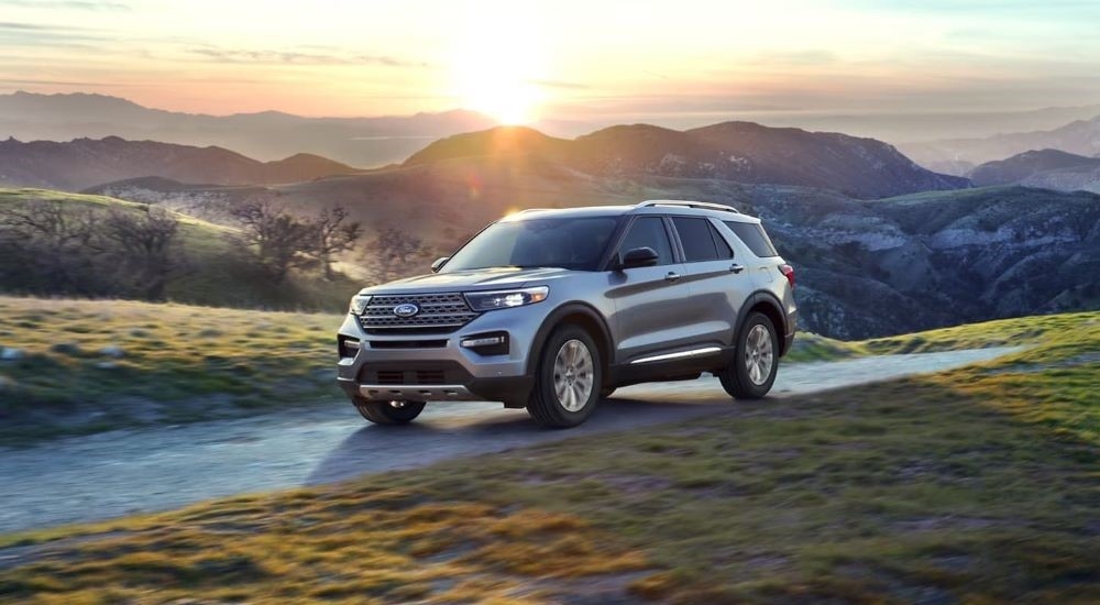 A silver 2022 Ford Explorer is shown driving on an open road.