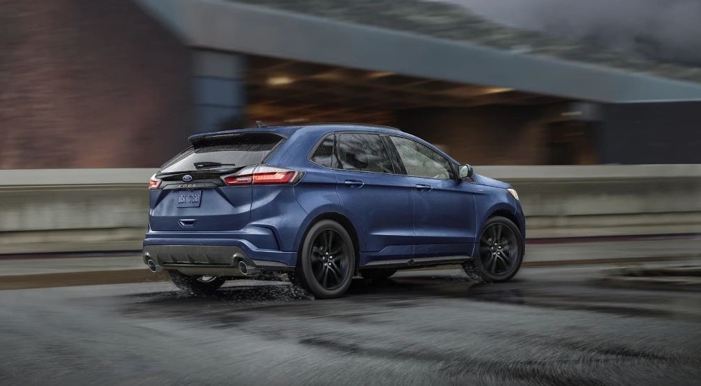 A blue 2022 Ford Edge ST is shown on wet pavement.