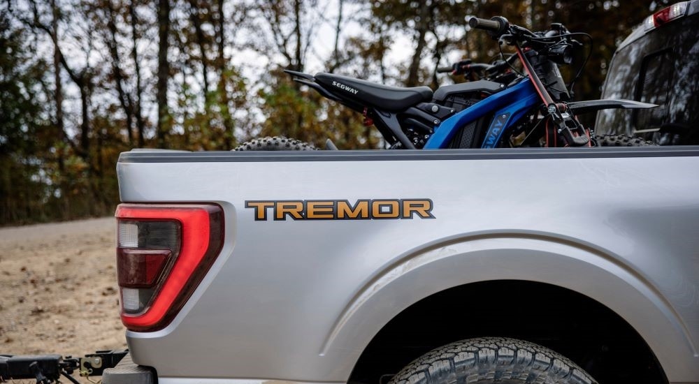 A close up shows the Tremor badge on the bed of a silver 2021 Ford F-150 Tremor.