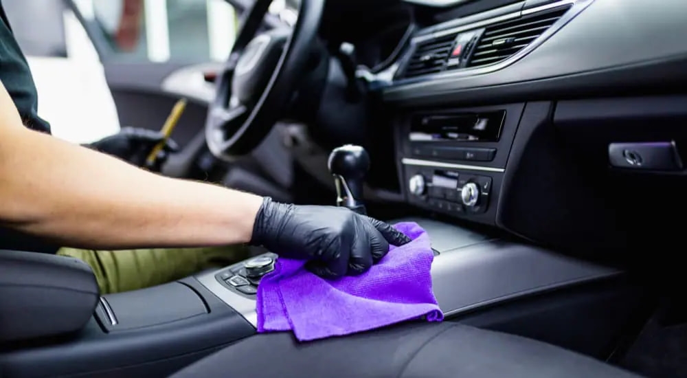 A person is shown detailing the interior of their vehicle.