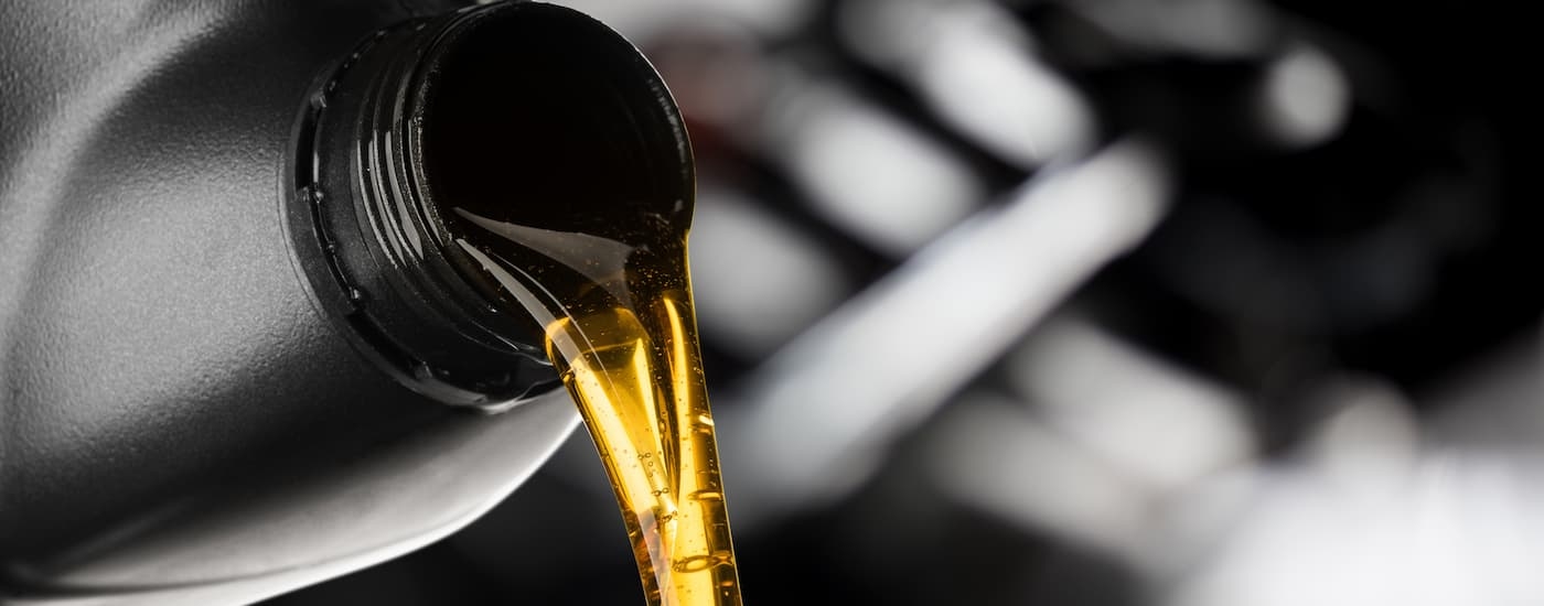 A close up of engine oil pouring out of a bottle is shown.