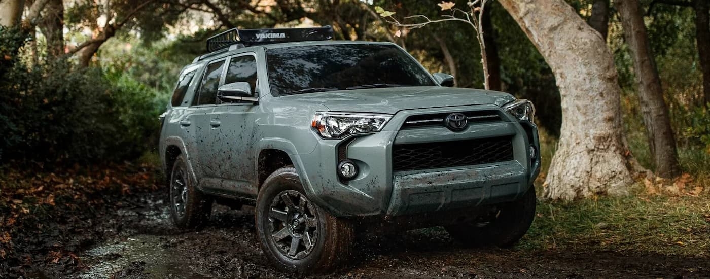 A grey 2022 Toyota 4Runner Trail Edition is shown off-roading on a muddy trail.