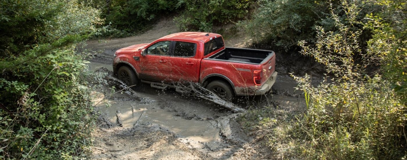 A red 2021 Ford Ranger Tremor Lariat is shown kicking up mud.