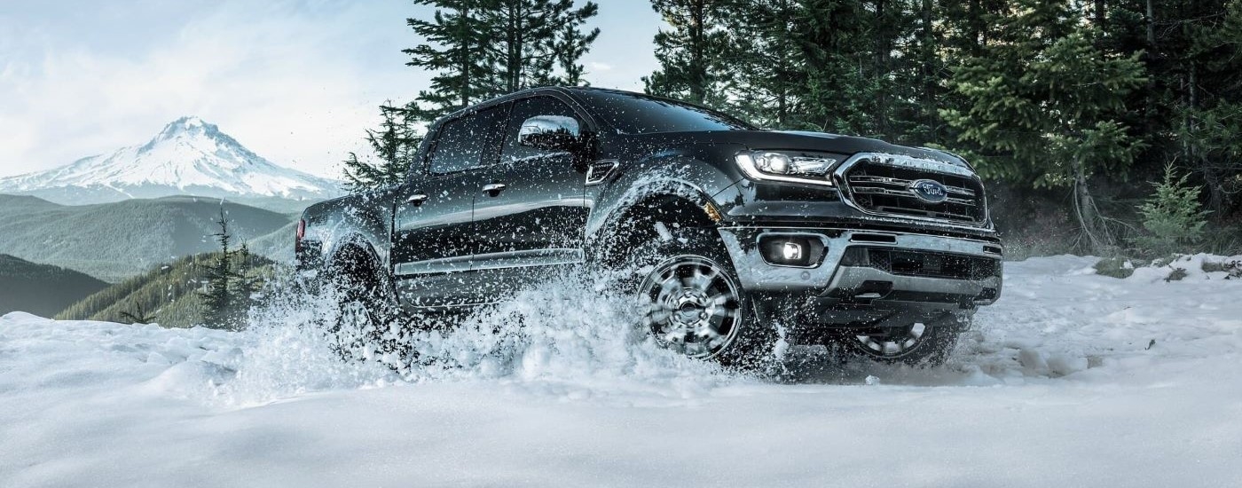 A black 2023 Ford Ranger FX4 is shown kicking up snow.