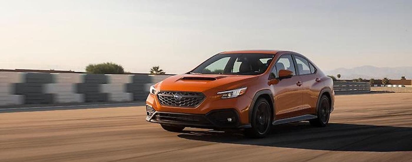 An orange 2023 Subaru WRX is shown from the front at an angle.