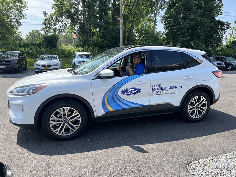 Image of the Ford mobile service vehicle with the driver showing his thumbs up.