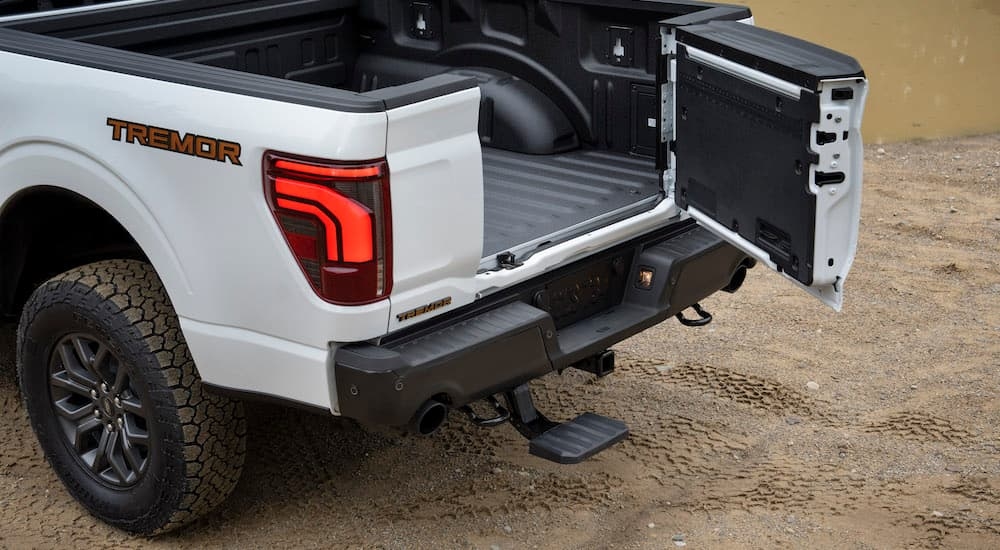 A white 2024 Ford F-150 Tremor is shown from the rear at an angle with the tailgate open.