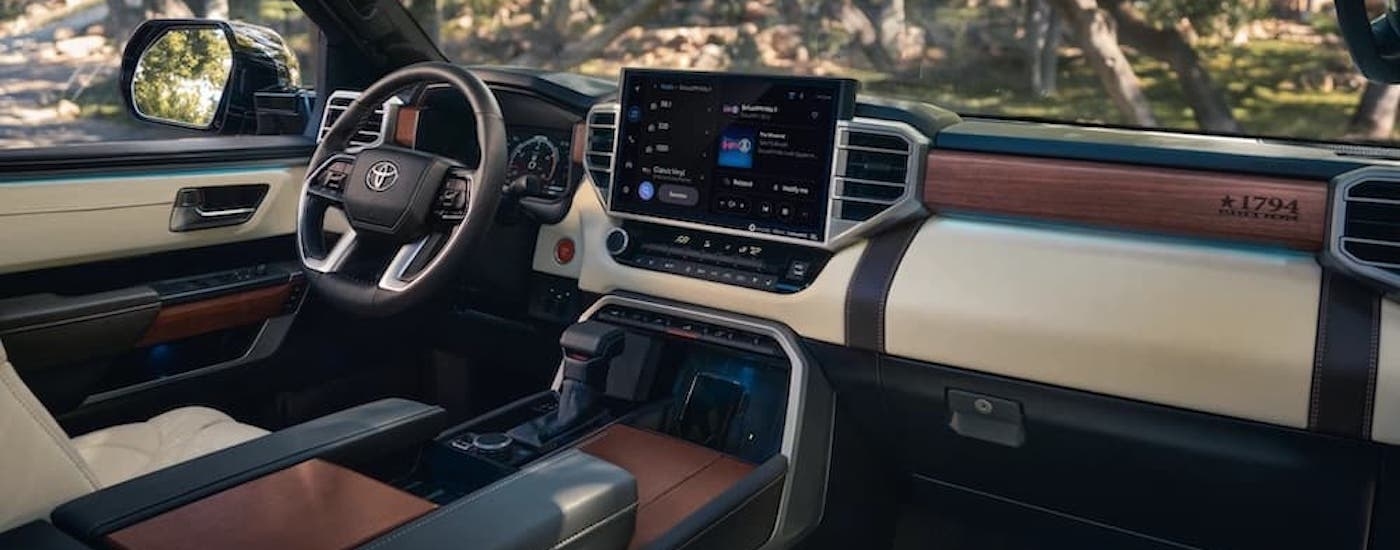 The tan and brown interior of a 2023 Toyota Tundra is shown from the passenger seat.