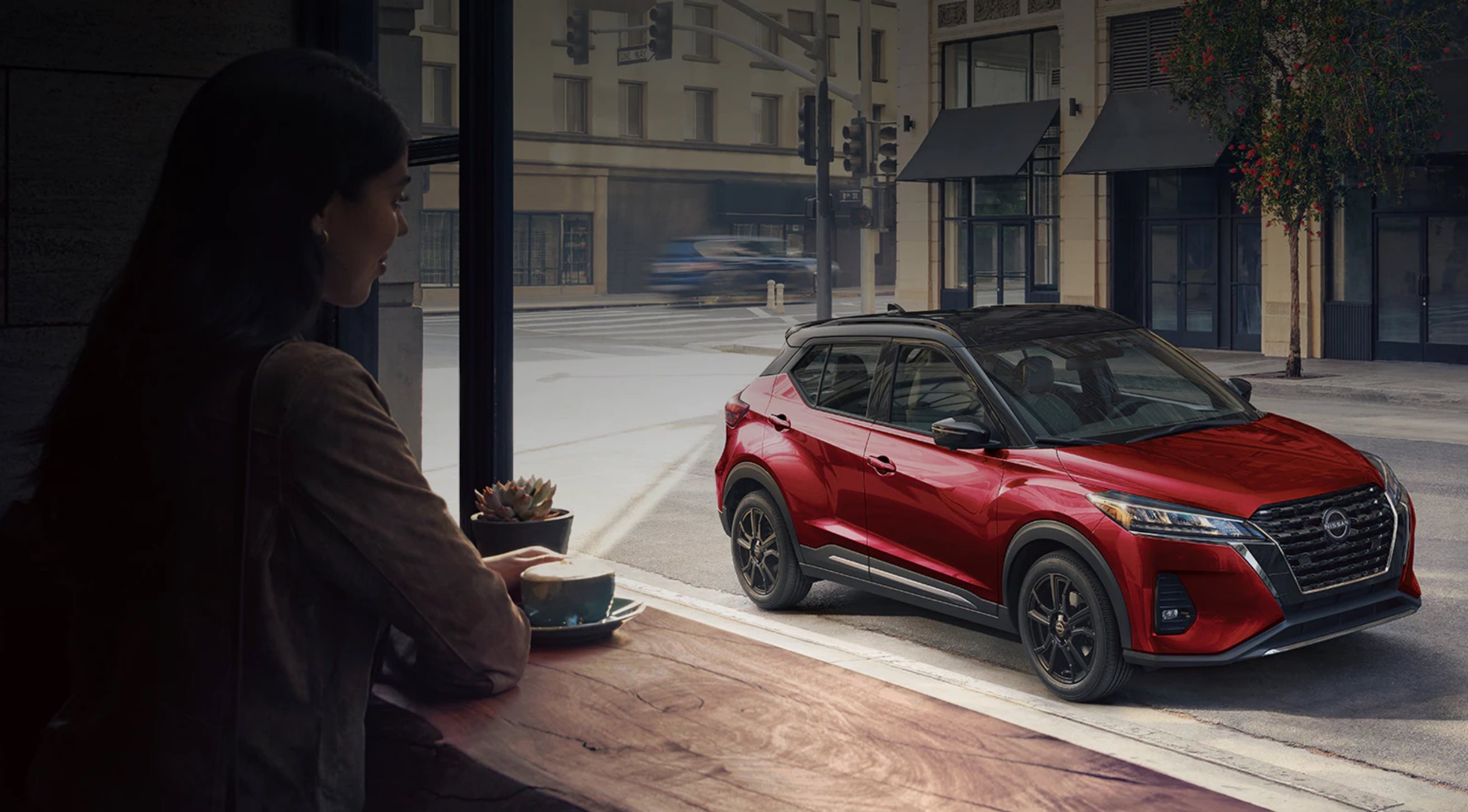 Women in window admiring 2024 Nissan Kicks in Yukon, OK