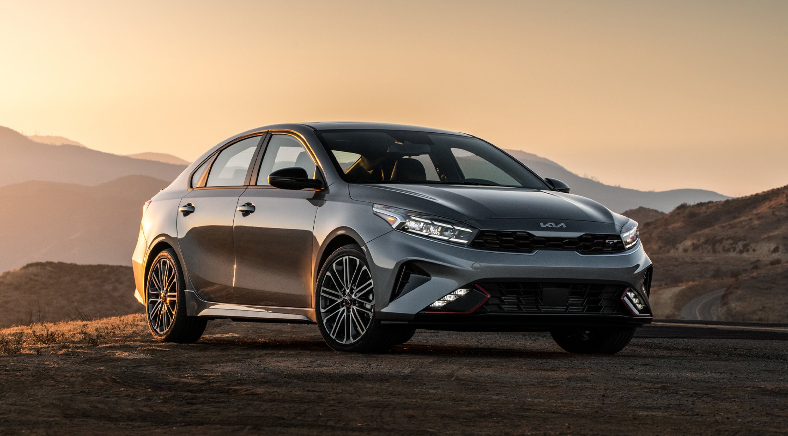 2024 Kia Forte in grey parked on side of mountain pass.