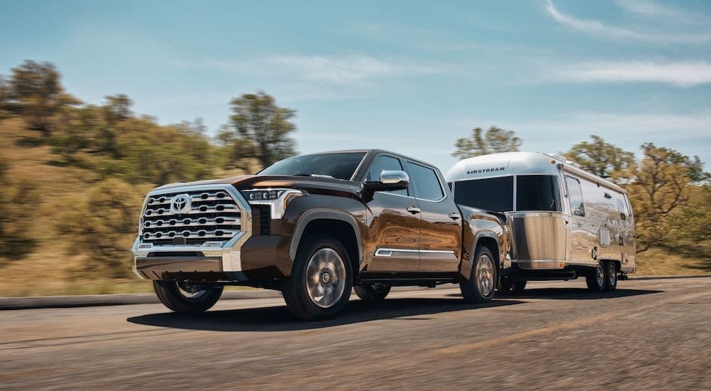 A brown 2024 Toyota Tundra 1794 Edition is shown towing an Airstream camper after leaving a Toyota Tundra dealer.
