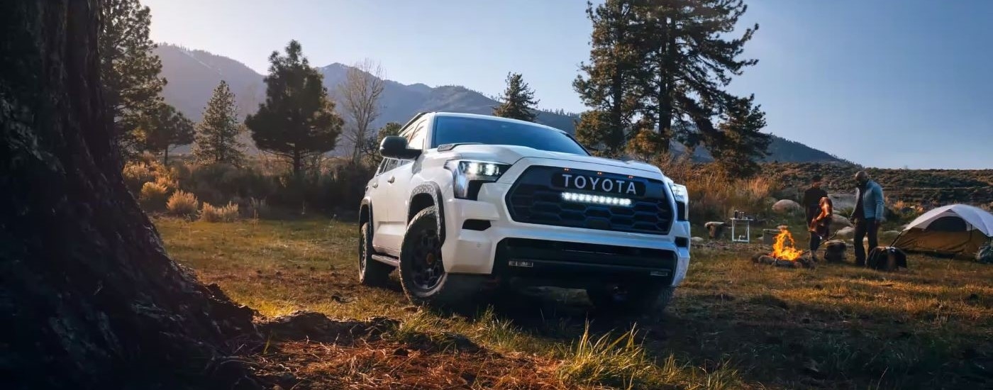 A white 2024 Toyota Sequoia TRD Pro is shown at a campsite.