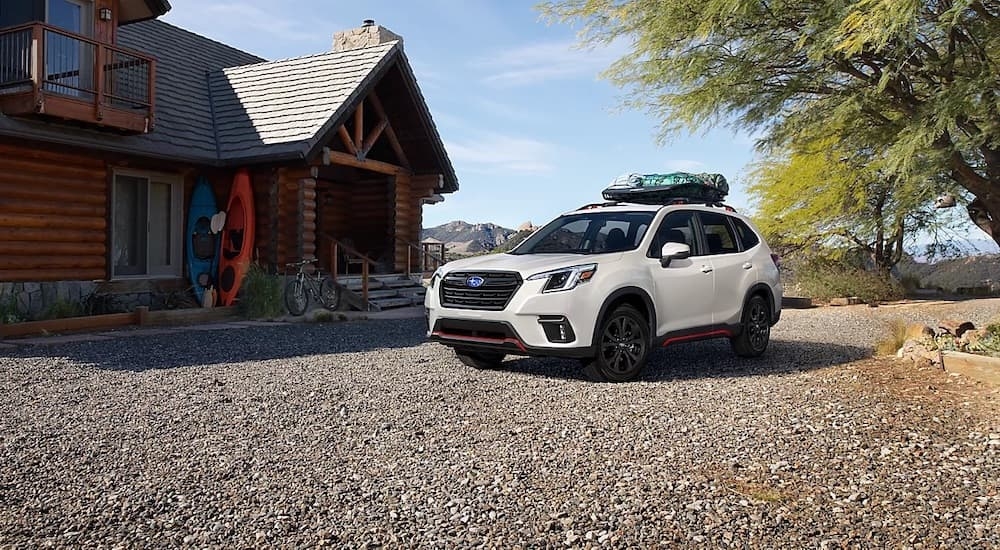 A white 2024 Subaru Forester is shown from the front at an angle after leaving a car dealership near Hudson.