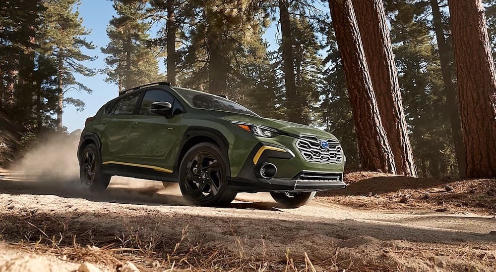A green 2024 Subaru Crosstrek Wilderness is shown from the front at an angle.