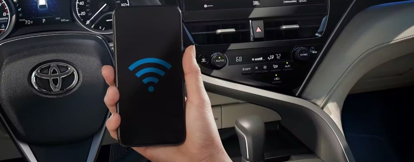 A wifi connectivity symbol is shown on a phone in a 2024 Toyota Camry XLE.