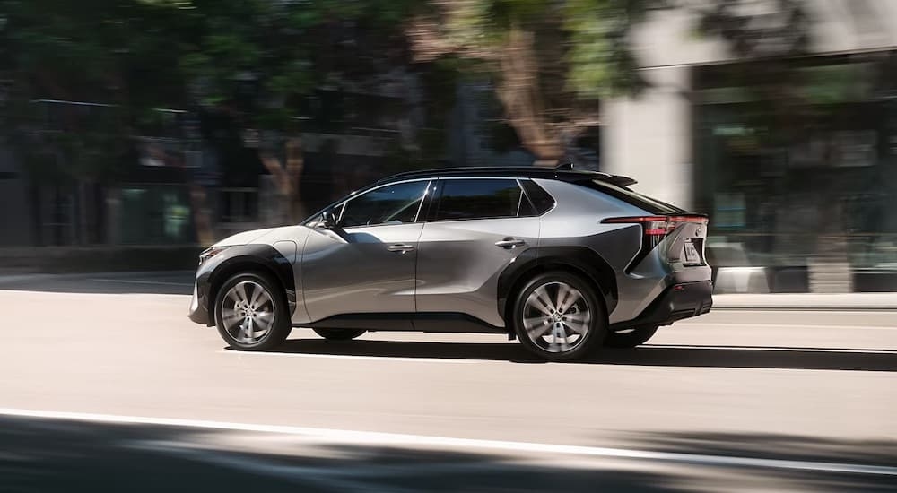 A silver 2023 Toyota BZ4x is shown from the side on a city street.