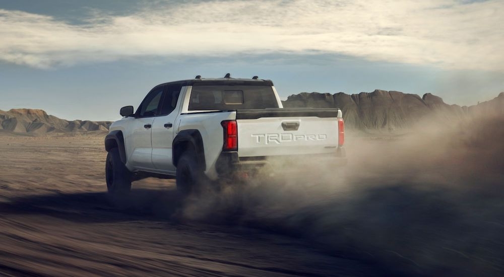 A white 2024 Toyota Tacoma TRD Pro is shown from rear at an angle while off-road.