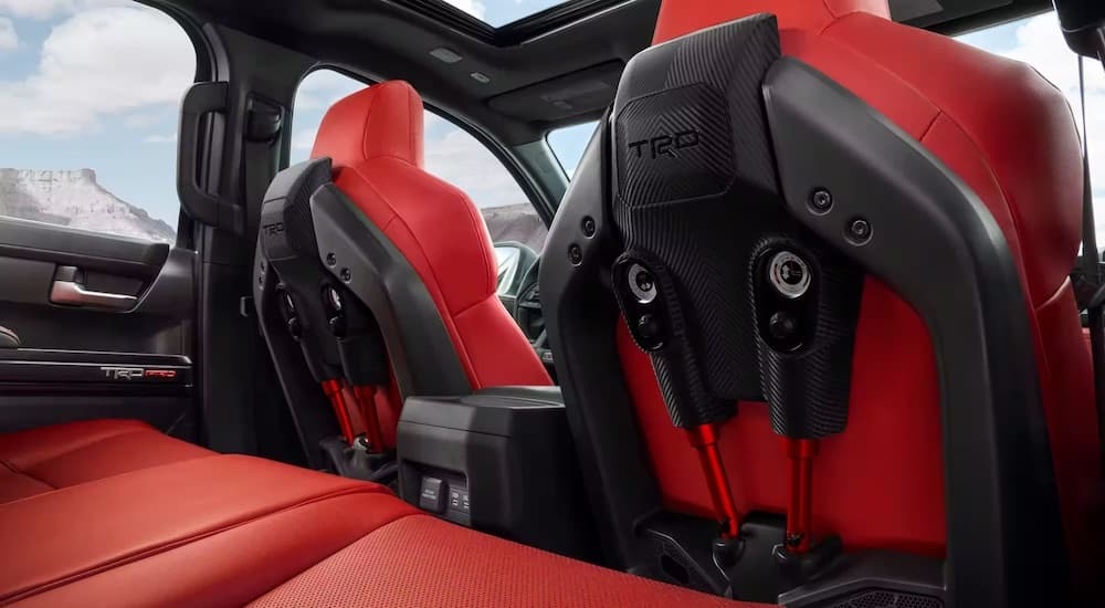 The red front IsoDynamic seats of a 2024 Toyota Tacoma TRD Pro is shown from the back seat.