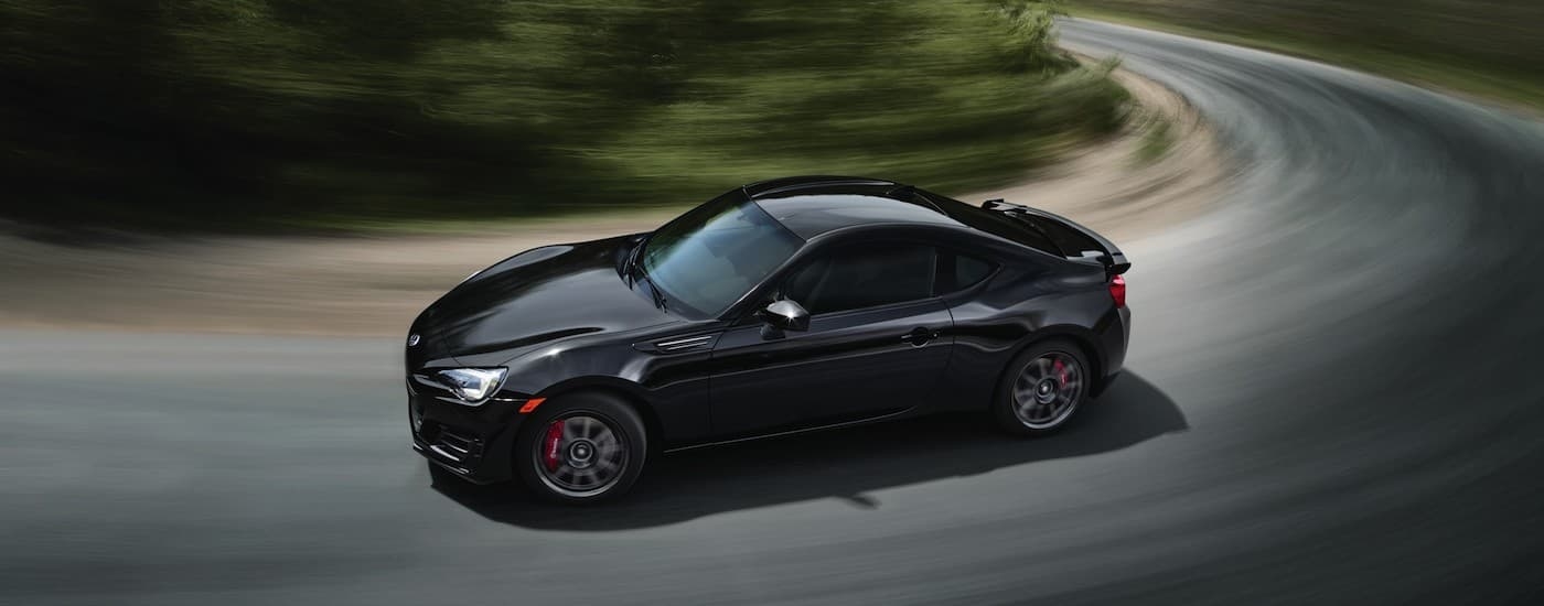 A black 2018 Subaru BRZ is shown from the side while taking a corner after leaving a used Subaru dealership near Red Hook.