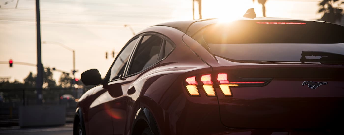 A close-up shows the rear of a red 2024 Ford Mustang Mach-E.