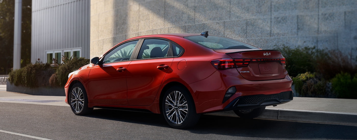 A red 2024 Kia Forte for sale is shown from the rear at an angle.