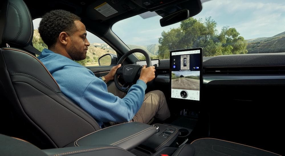 The black interior of a 2024 Ford Mustang Mach-E is shown from the passenger seat.