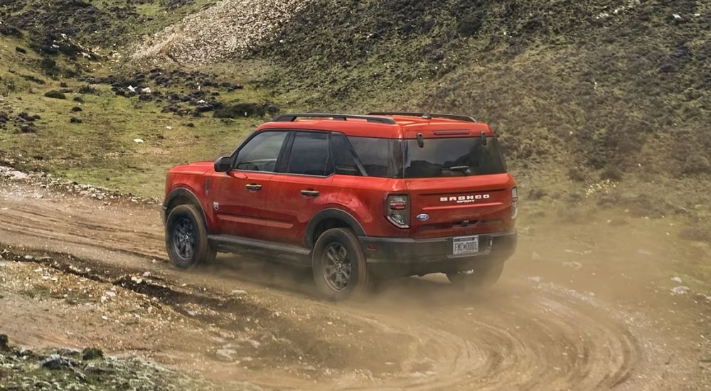 An orange 2024 Ford Bronco Sport Big Bend is shown kicking up dust.