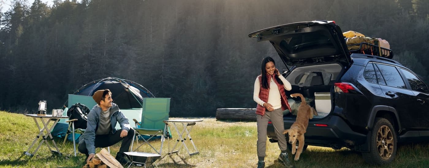 A family is camping next to their 2024 Toyota RAV4 Woodland Edition.