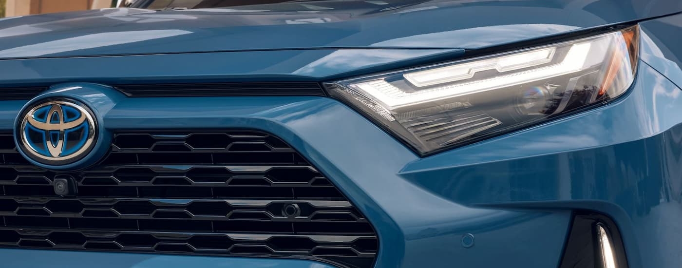 A close up of the grille on a blue 2024 Toyota RAV4 Hybrid XSE.