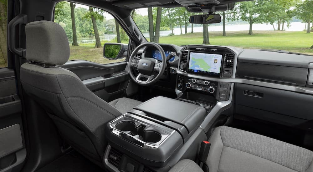 The grey interior of a 2024 Ford F-150 XLT is shown from behind the passenger seat.