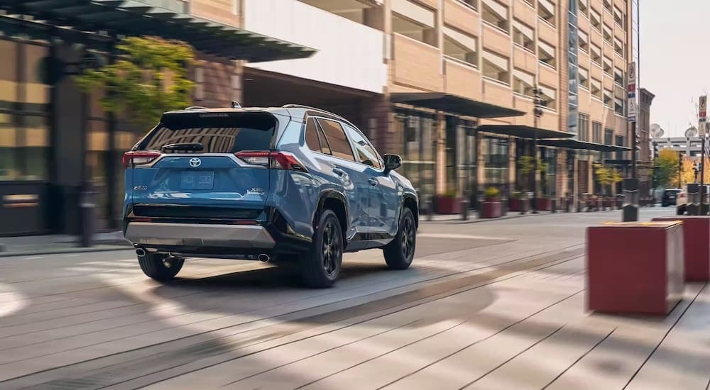 A blue 2024 Toyota RAV4 XSE is shown from the rear at an angle.