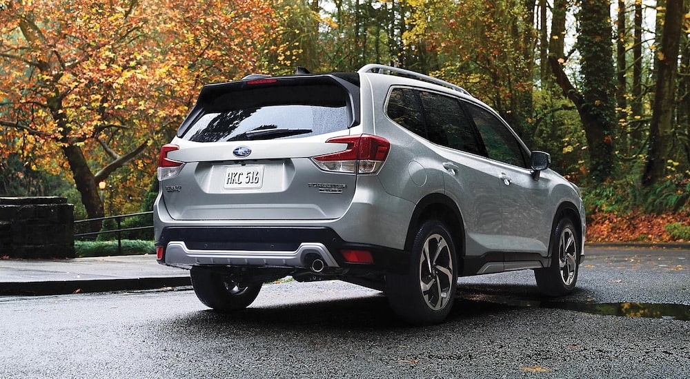 A silver 2024 Subaru Forester Touring is shown from the rear at an angle.