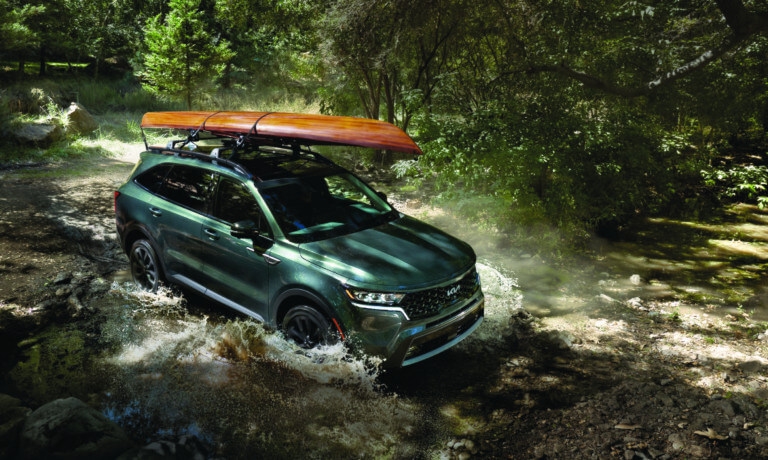 2024 Kia Sorento driving in a stream with a kayak