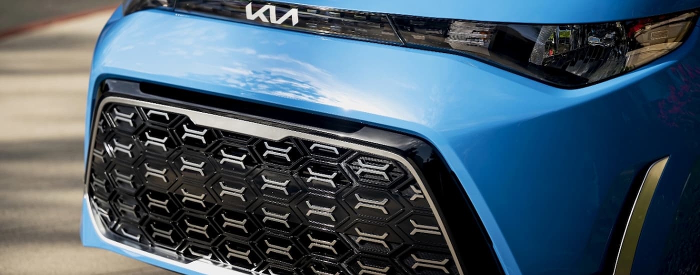 A close up of the front of a bright blue 2024 Kia Soul at a Kia dealer near Karnes City.