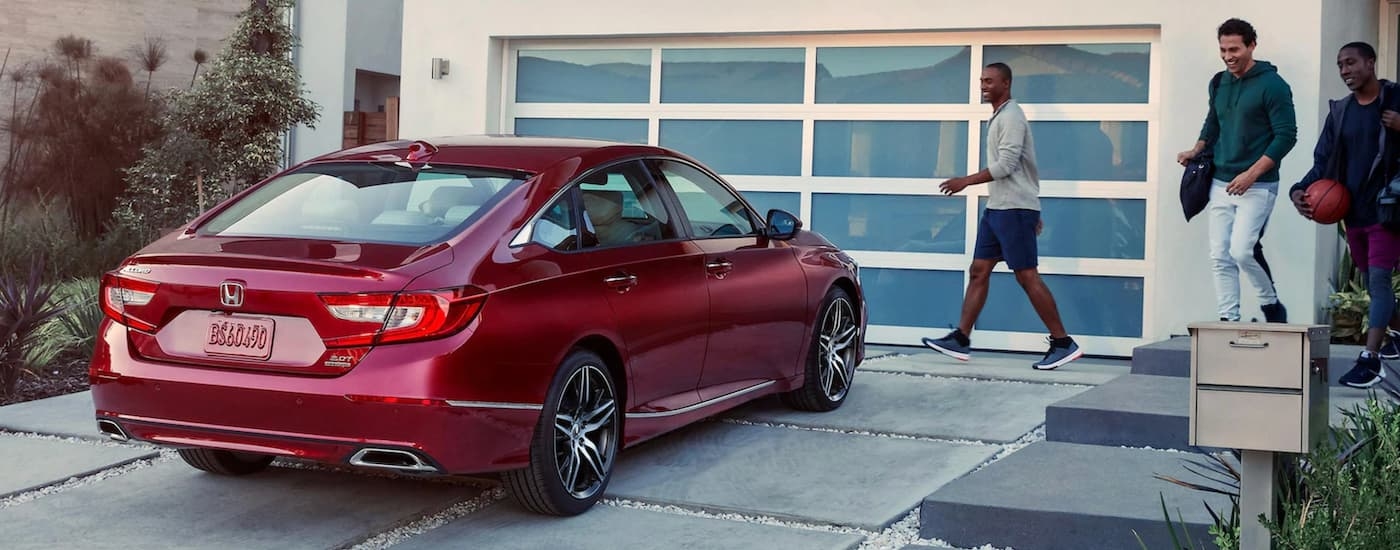 A red 2020 Honda Accord is shown from the rear at an angle in a driveway.