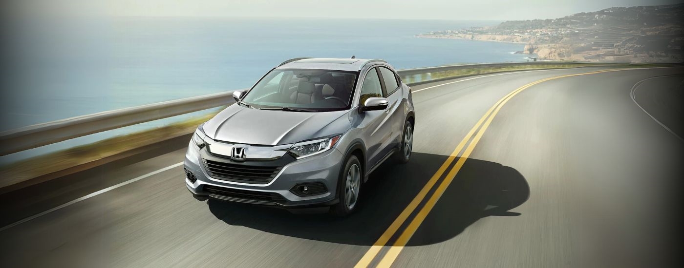 A silver 2022 Honda HR-V driving on an elevated coastal road.