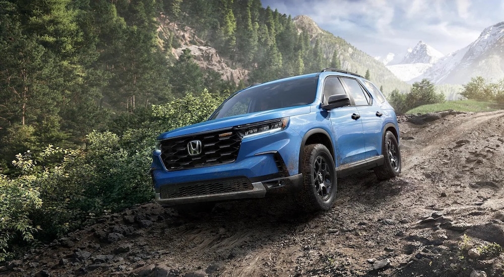 A blue 2024 Honda Pilot TrailSport is shown from the front at an angle after leaving a Honda dealer.