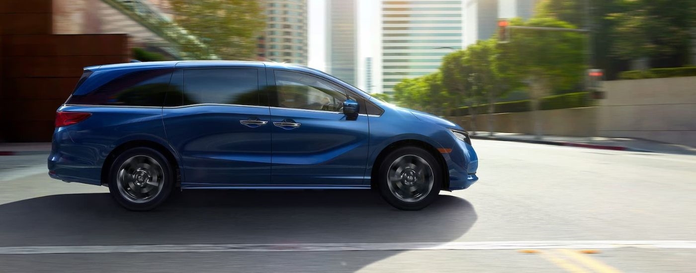 A blue 2024 Honda Odyssey Elite driving through the city to a Honda dealer in West New York, NJ.