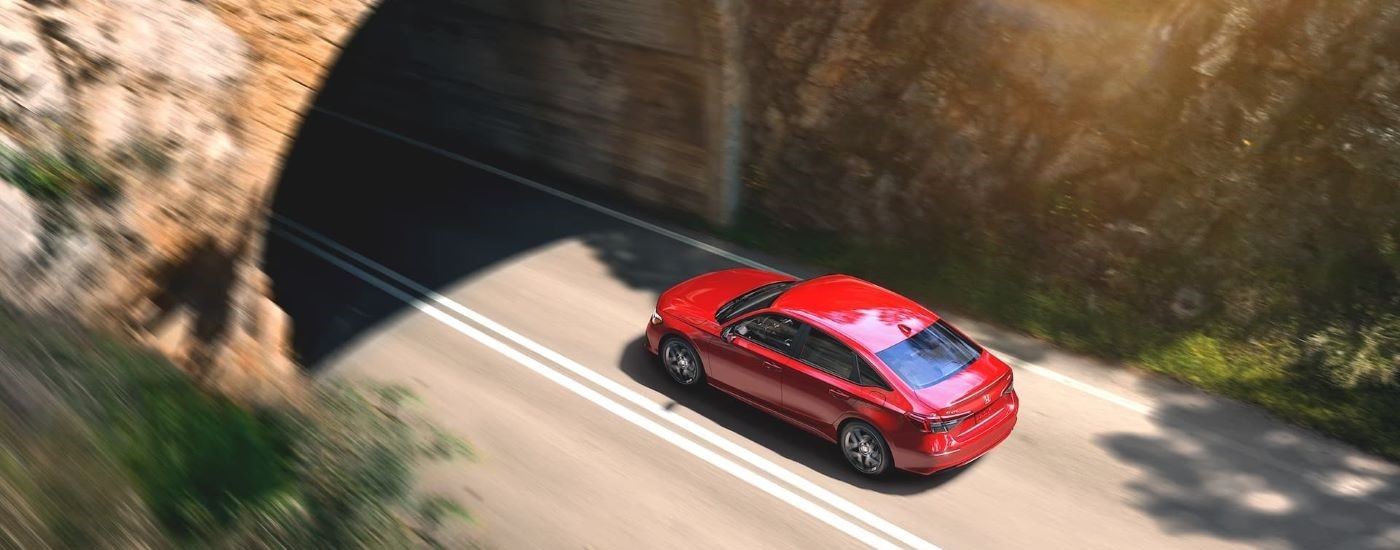 Aerial view of a red 2023 Honda Civic Sedan entering a tunnel.