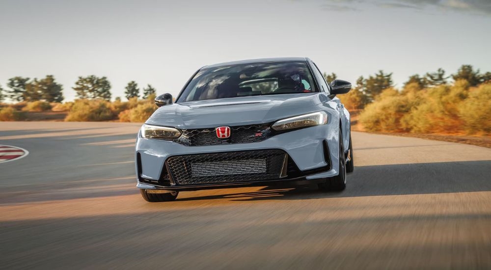 A popular Honda Civic for sale, a grey 2024 Honda Civic Type R, is shown on a racetrack.