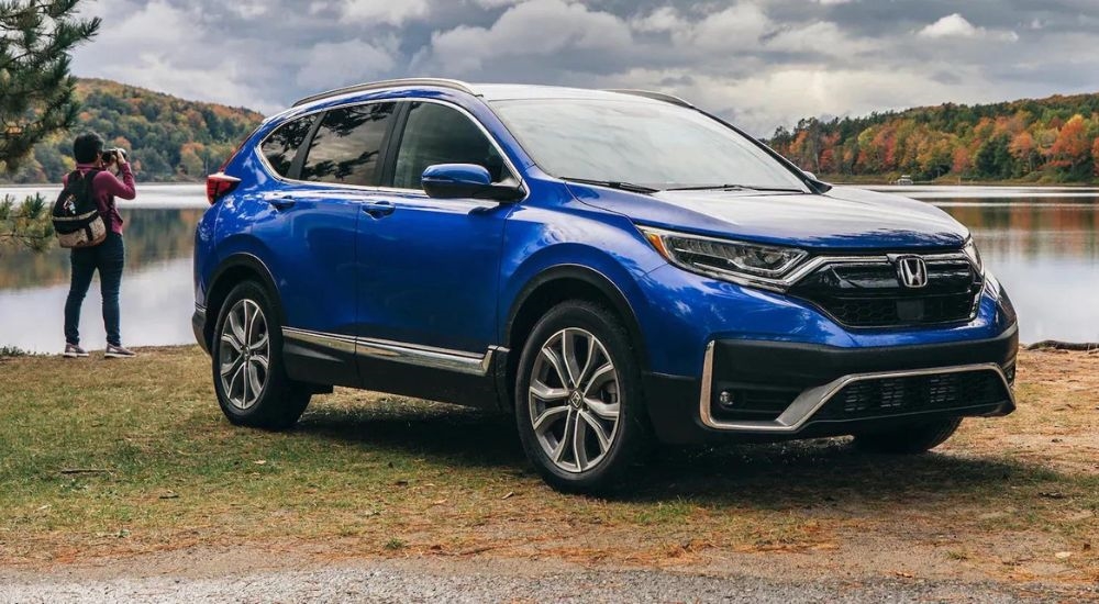 A blue 2022 Honda CR-V Touring is shown parked near a lake.