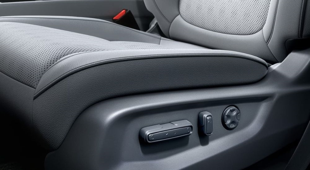A close up shows the grey adjustable seat toggles on a 2024 Honda Odyssey Elite.