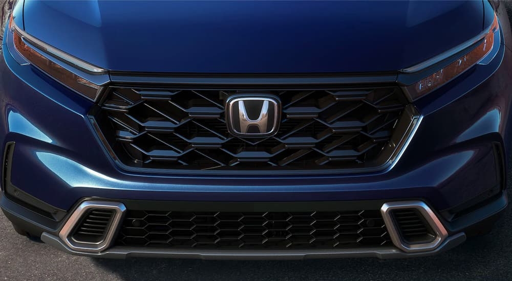 A close up of the front of a dark blue 2024 Honda CR-V at a Honda dealer.