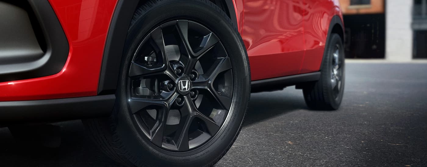 A close up of the black rim on a red 2023 Honda HR-V Sport.