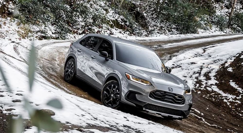 A grey 2024 Honda HR-V is shown descending a snowy hill.