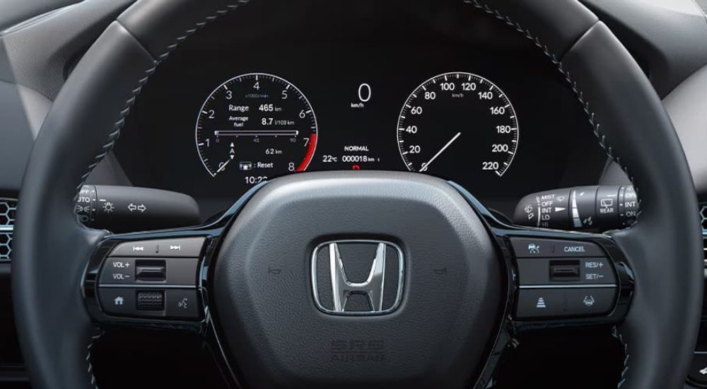 A close up shows the black steering wheel and gauges in a 2024 Honda HR-V.