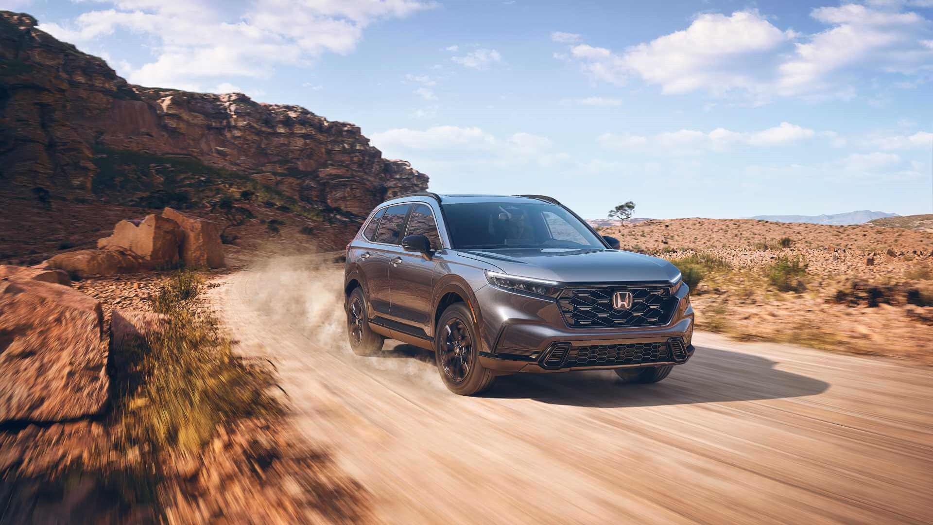 Dynamic photo of new Honda CR-V at high speed on a gravel road in desert area