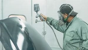 collision repair tech painting vehicle